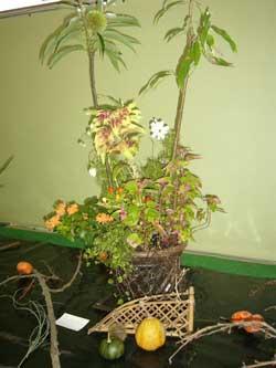 かごの鉢に草花と黄色い実が写った写真