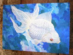 壁に貼られた白い金魚の青い色調の絵の写真