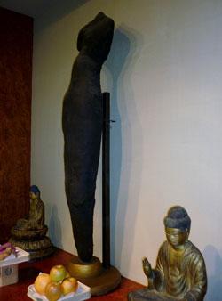木彫りの仏像と座っている仏像が展示されている写真