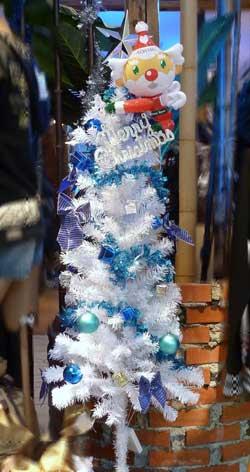 メリークリスマスの白い飾りと青い玉が飾られた白と青いろが混ざったクリスマスツリーの写真