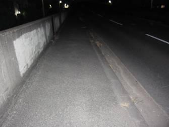夜の道路を車のライトで照らされている写真