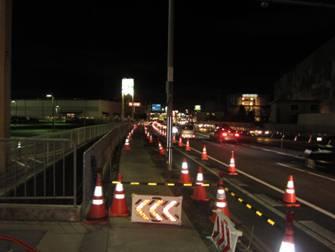 赤いコーンが並ぶ夜の車道の写真