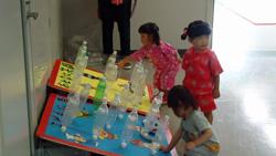 子供たちがペットボトルで作られた輪投げをして遊んでいる写真