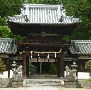 森を背景に建つ矢田坐久志玉比古神社拝殿の外観写真