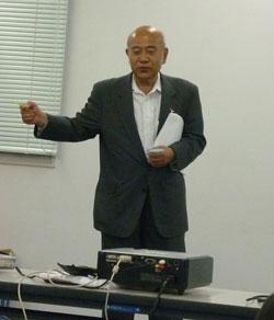 金魚すくいの名人の田村和勇氏が講義をしているの写真