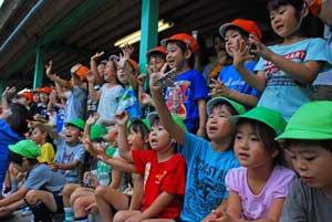 放蝶したオオムラサキを手を振って送る子供たちの写真