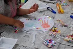 子どもが団扇に絵を描いている写真