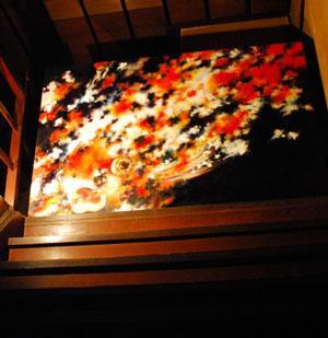 階段に飾られている金魚の油絵の写真