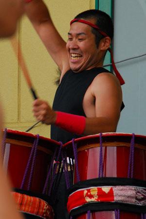 桶太鼓を笑顔で叩いている男性の写真