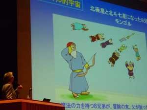 弓を持つ男性と、空中を飛ぶ男性たちのモンゴル神話のイラストが描かれたスクリーンの写真