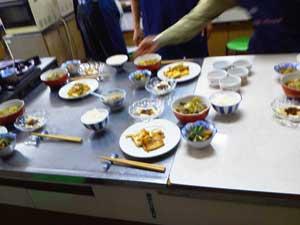 調理されたせんべい汁と副菜が並んだテーブルの写真
