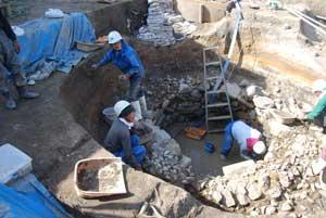 石組み井戸で3人の人が作業をしている写真