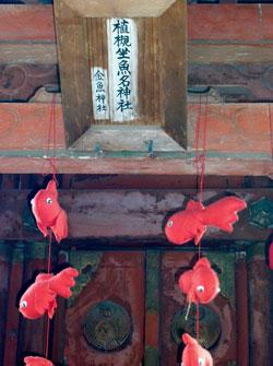 金魚の人形が飾られている鳥居の、神社名が書かれた箇所の写真