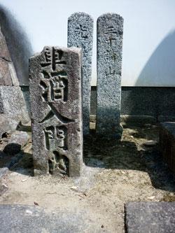 文字が書かれた石碑の後ろに少し多きめの2つの石碑の写真
