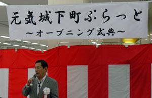 紅白の垂れ幕のようなものの前で上田市長があいさつをしている様子の写真