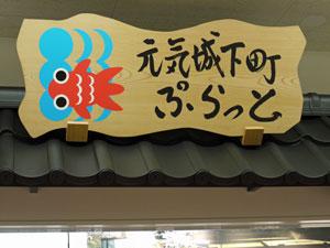 金魚のイラストと「元気城下町ぷらっと」と書かれた木製の看板の写真