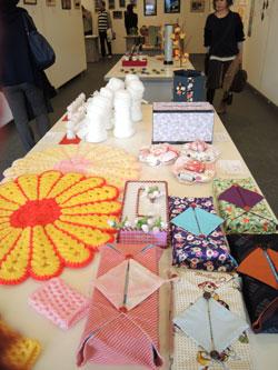 テーブルの上に編み物の作品など、手作りの作品が並べられている写真