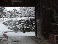 雪が積もった郡山城の入りに傘が置いてある写真