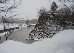 御堀と石垣に雪が積もった写真