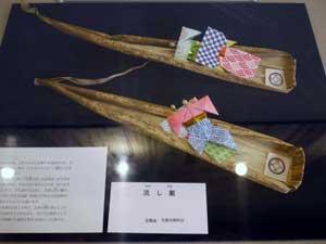 笹船のようなものに折り紙で作られたひな人形が乗っている、流し雛の写真