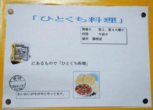 画用紙に「ひとくち料理」と書かれ、冷蔵庫と料理が描かれている写真
