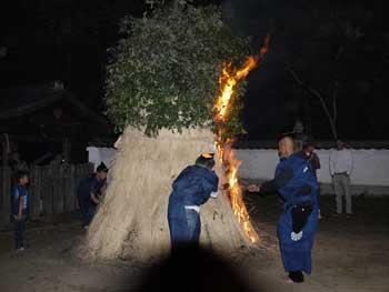大松明に火をつけている男性二人の写真