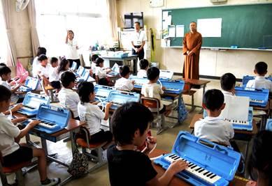 教室で鍵盤ハーモニカを演奏する子供たちの写真