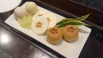 大和橘を使用したお饅頭、煎餅などの和菓子が白い長方形の皿に盛りつけられている写真