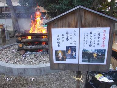 焚き火と木製の案内板の写真