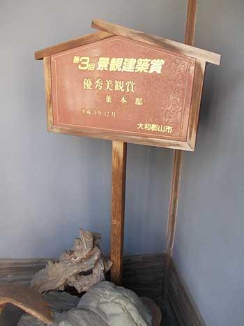 家屋の壁際に設置された、「景観建築賞」と書かれた木製の看板の写真