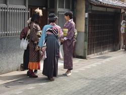 着物や袴を着た4人の女性が道の端で話している写真