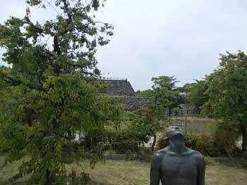 建物の遠景と上半身の銅像の写真
