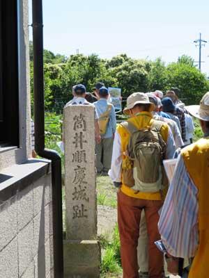 筒井順慶城址と文字が彫られている石碑と並んでいる人々の写真