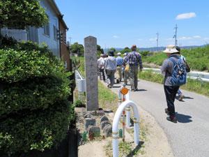道の横に立っている六十六度供養と文字が彫られた石碑の写真