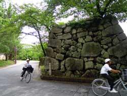 鉄御門の周りを走る自転車に乗った2人の写真