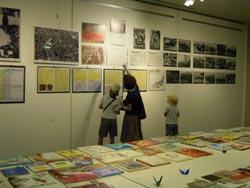 壁に貼られた戦争に関する展示を見ている親子の写真