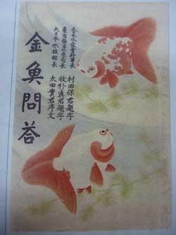 赤と白の柄の金魚と水草と、脇に墨字の入った日本画の写真
