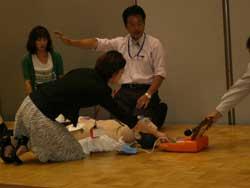 AEDの使用方法を実践する女性の写真