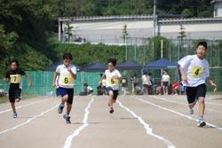 100メートル競争で一生懸命に走る子どもたちの写真