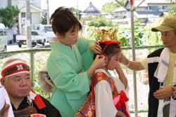 「順慶まつり」で衣装を着た稚児の髪型を直している和服姿の保護者の写真