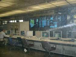 浄化センター施設内で大きなパネルとパソコンが並べられたコンピューター制御室の写真