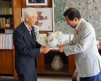 社会福祉協議会会長の上田市長に手渡しをしている海保勝雄副会長の写真