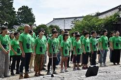 緑色のTシャツを着た男女が並んでいる写真