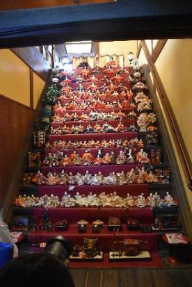 室内の階段を使って作られた人形や飾り物が置かれている14段の赤いひな壇の写真