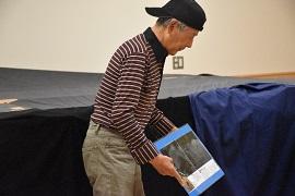 黒いキャップを反対にかぶった岩代さんが透明の箱を持っている写真