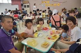 カレーを美味しく食べている園児たちとボランティアの先生の様子の写真