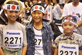 日本と書かれたはちまきを頭に締めている小学生の男女3人組の写真