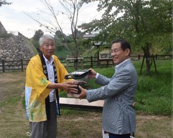 スズムシの贈呈式を行っている観光大使と市長の様子の写真