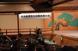 能舞台に「奈良県市町村政策自慢大会」と書かれた横断幕が飾られた写真
