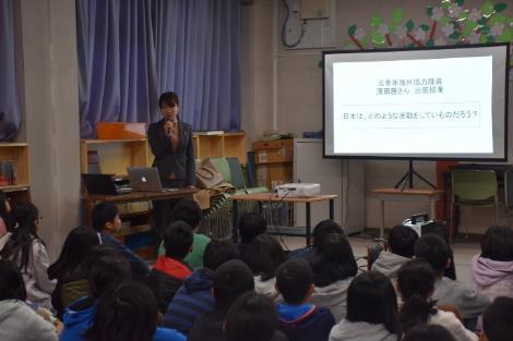 郡山西小学校で行われた、元青年海外協力隊員がスライドを使って子供たちに授業している所の写真